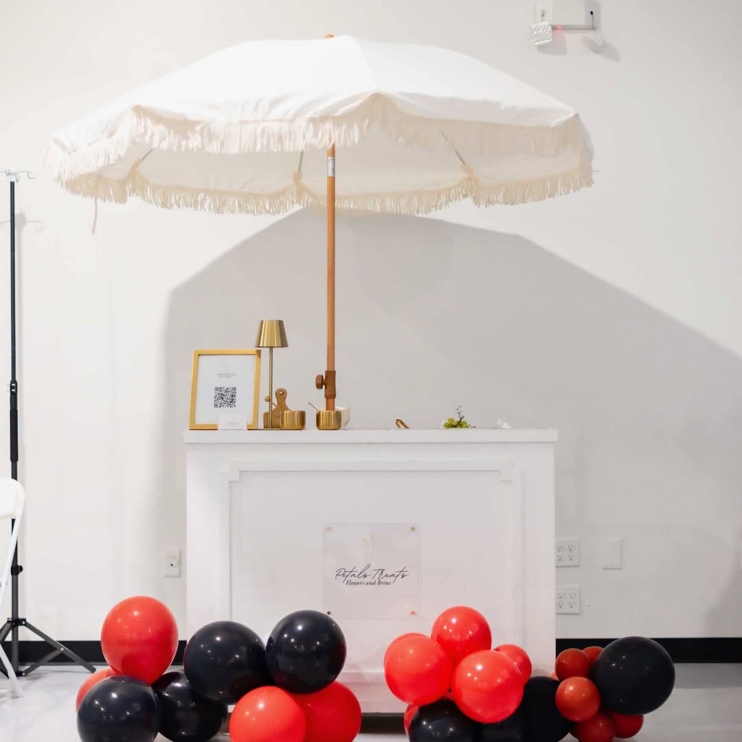 Petals Treats mobile cart with red and black balloon clusters under a fringed umbrella